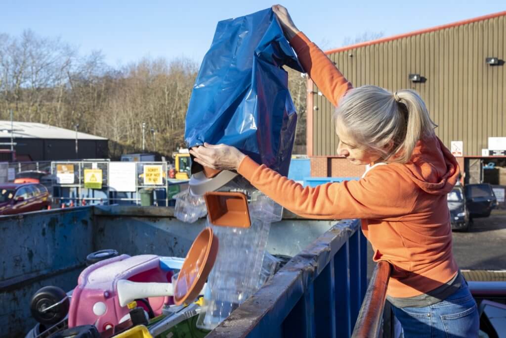 Woman emptying waste at tip